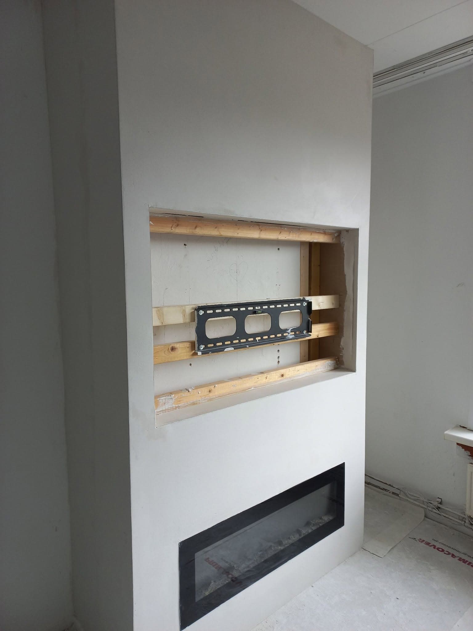 Strak afgewerkte wand rond een haard en nis