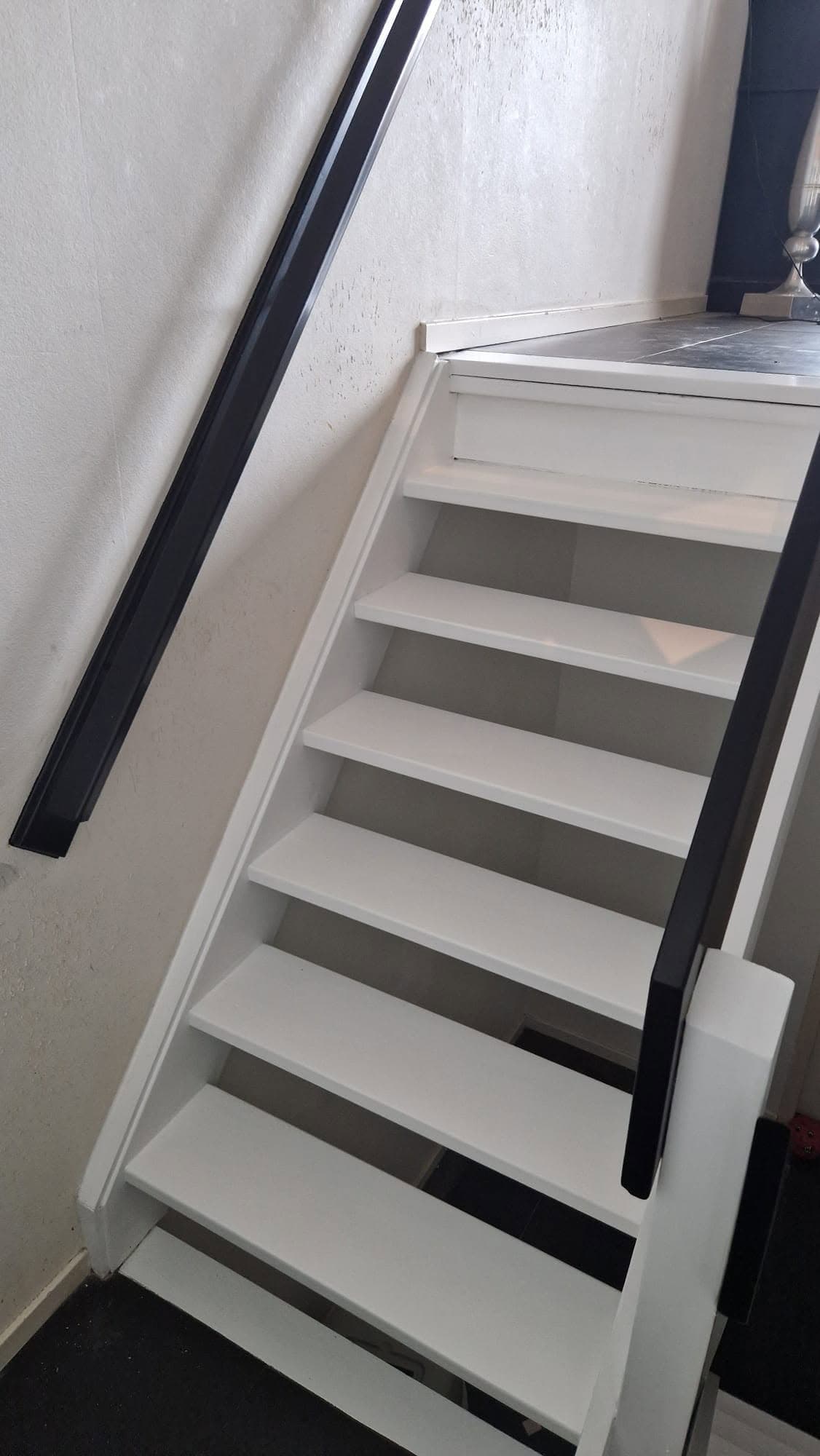 Witte trap met donkere leuning van dichtbij