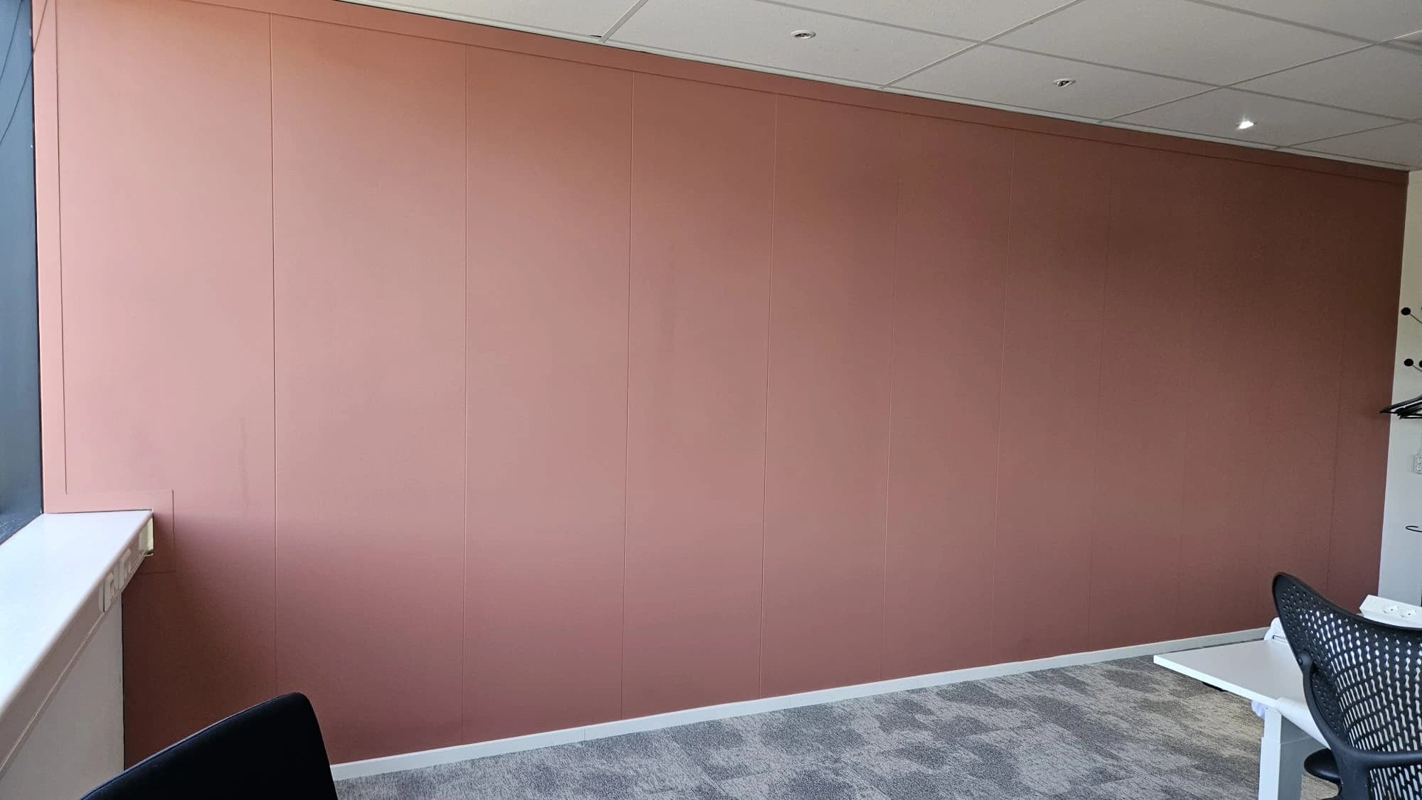 Warmroze geschilderde accentwand in een bedrijfspand