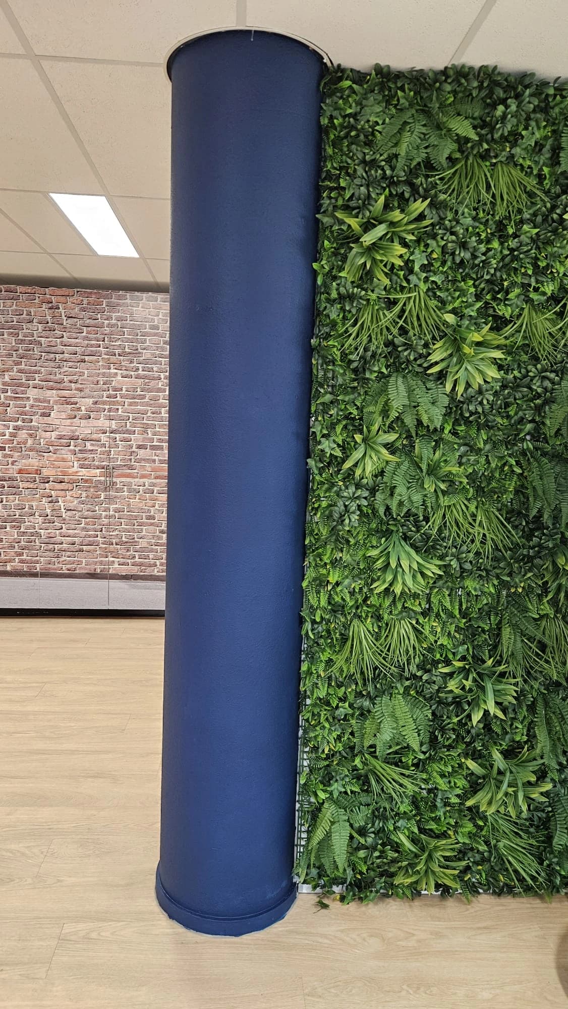 Donkerblauw geschilderde pilaar naast een groene wand